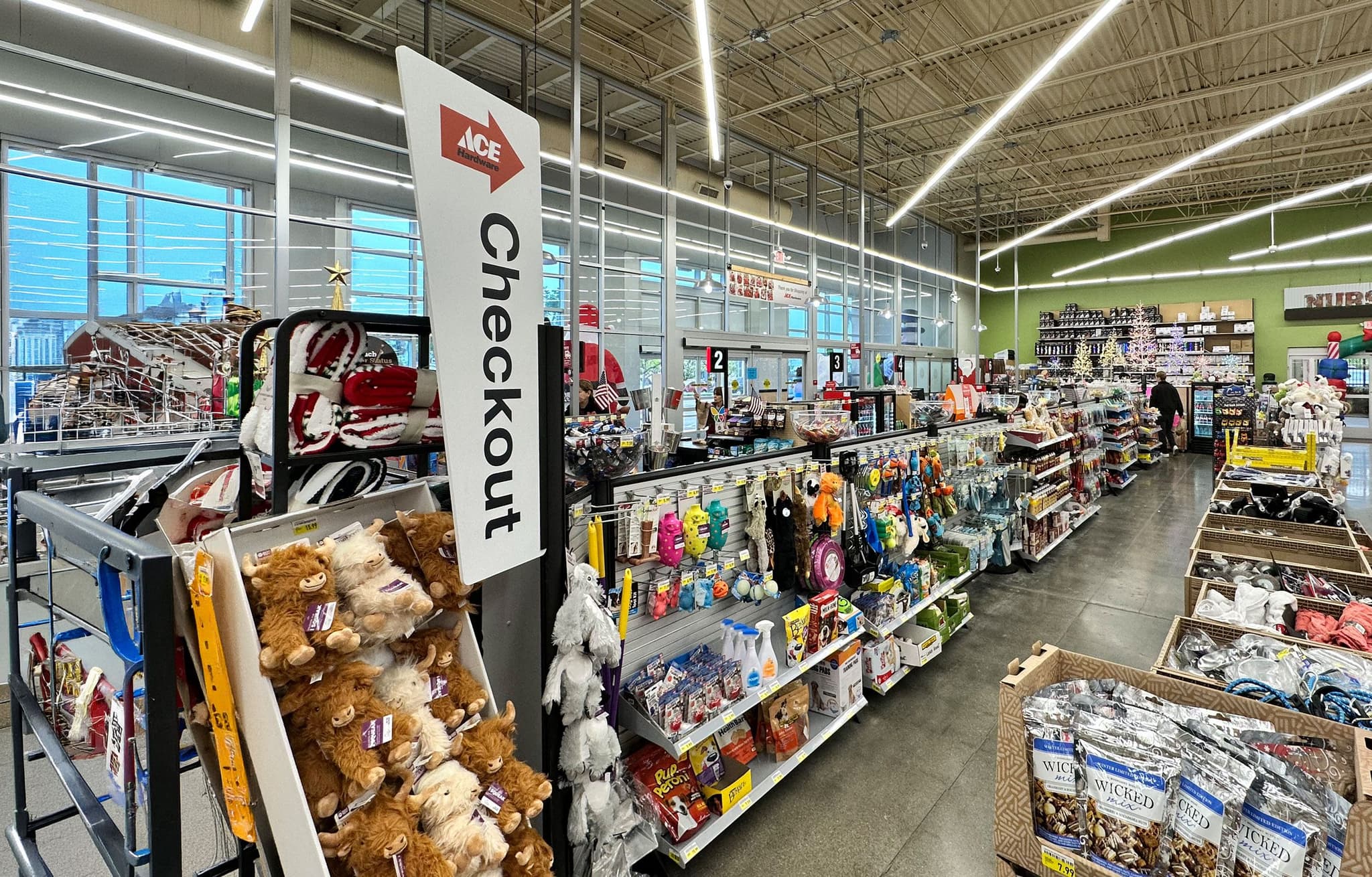 Partition posts with slatwall shelving and a banner sign merchandise the checkout queue at an ACE Hardware store.