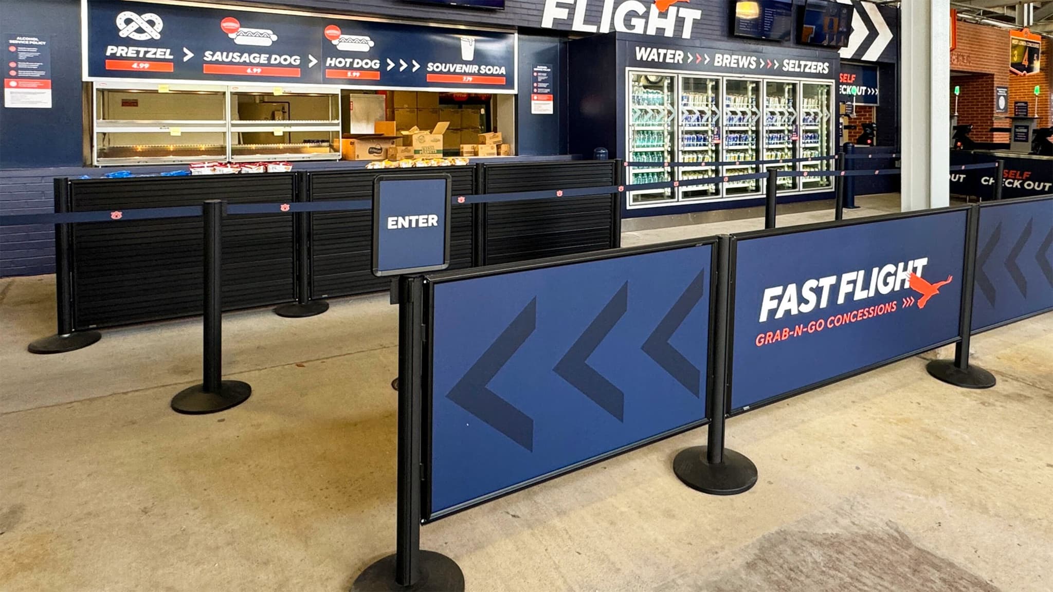 Beltrac stanchions with a post-top sign lead fans into the Fast Flight concession line at Auburn's Jordan-Hare Stadium.