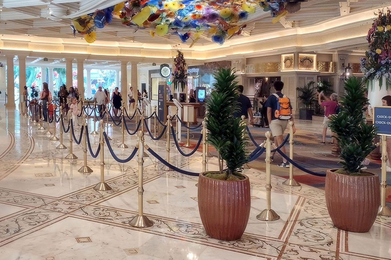 Brass traditional post and rope stanchions guide guests through the lobby check-in queue at the Bellagio hotel.
