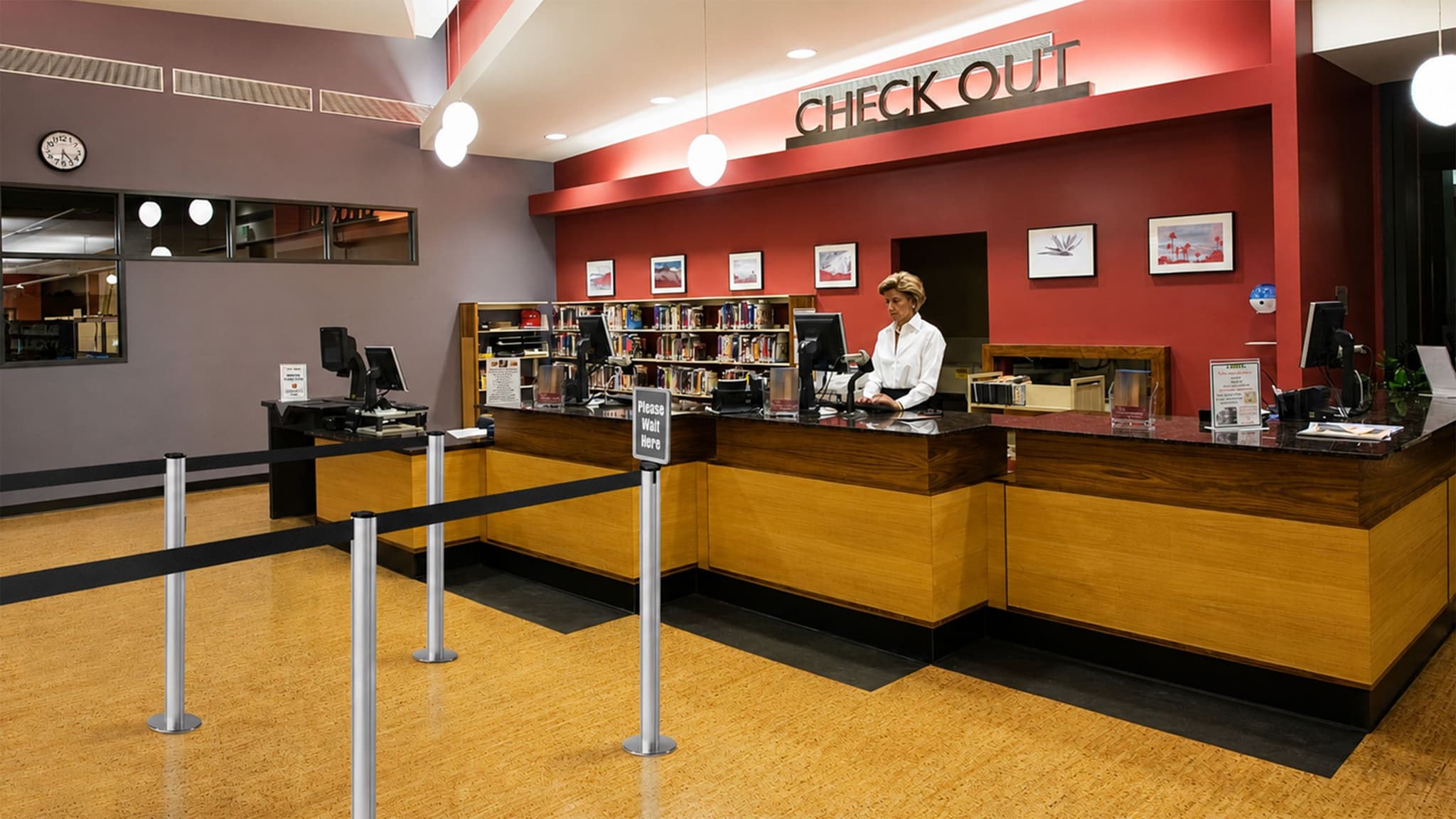 Beltrac retractable belt stanchions organize the checkout line at a college library service desk.