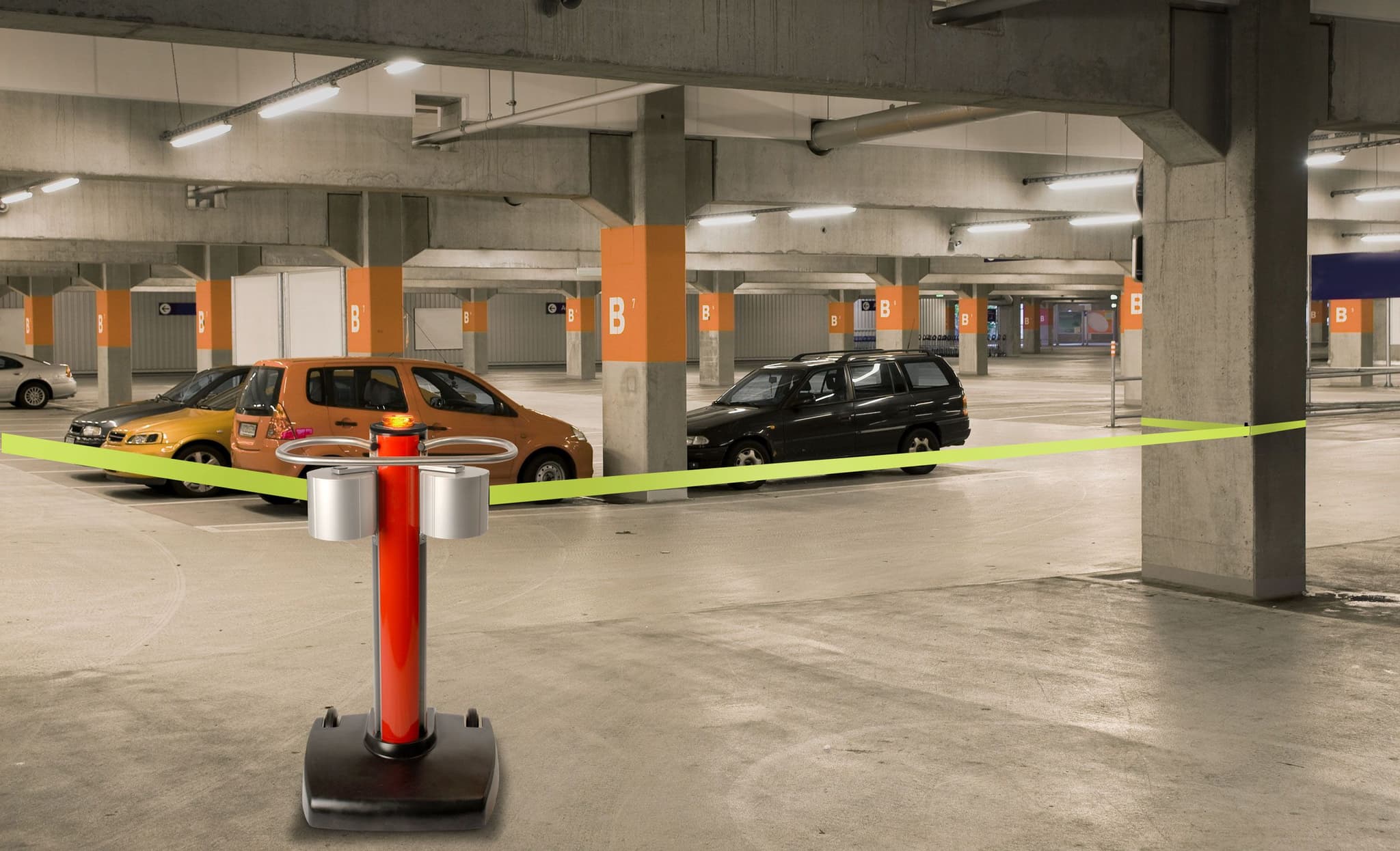 A JetTrac Dual mobile belt barrier blocks reserved spaces in a parking garage.