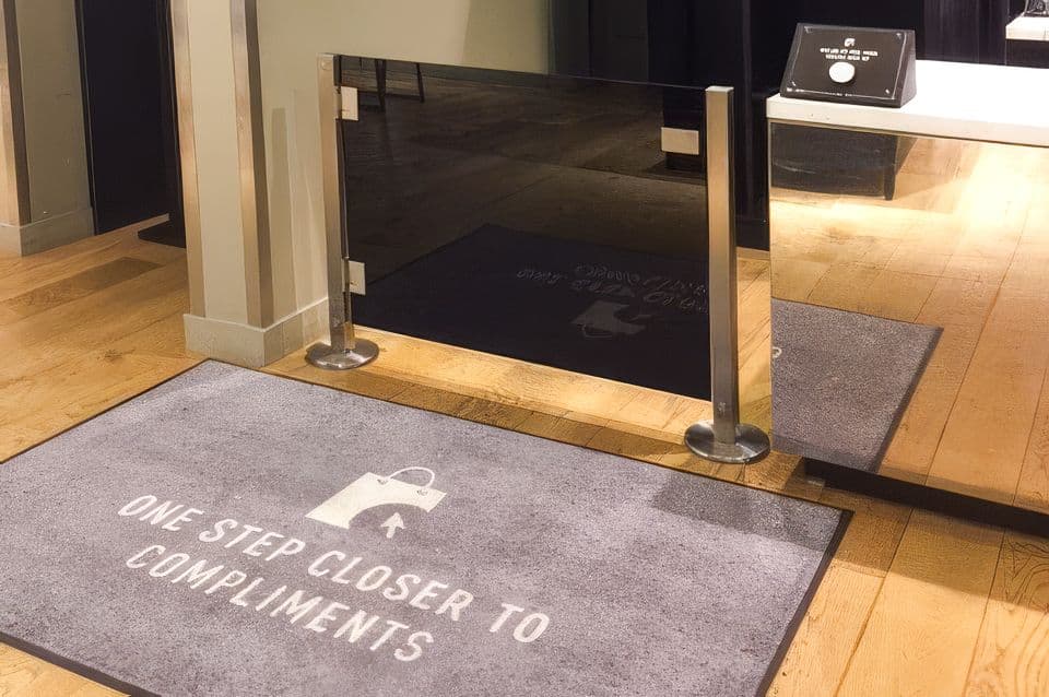 An Architectural Partition Wall gate controls access at the checkout counter of an Express store.
