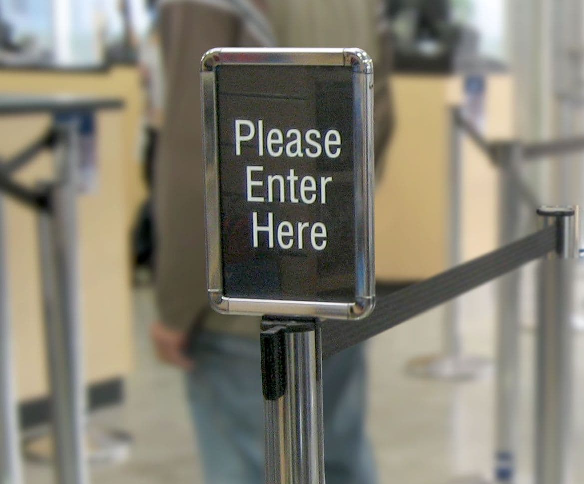 Post-top stanchion sign at a queue entrance