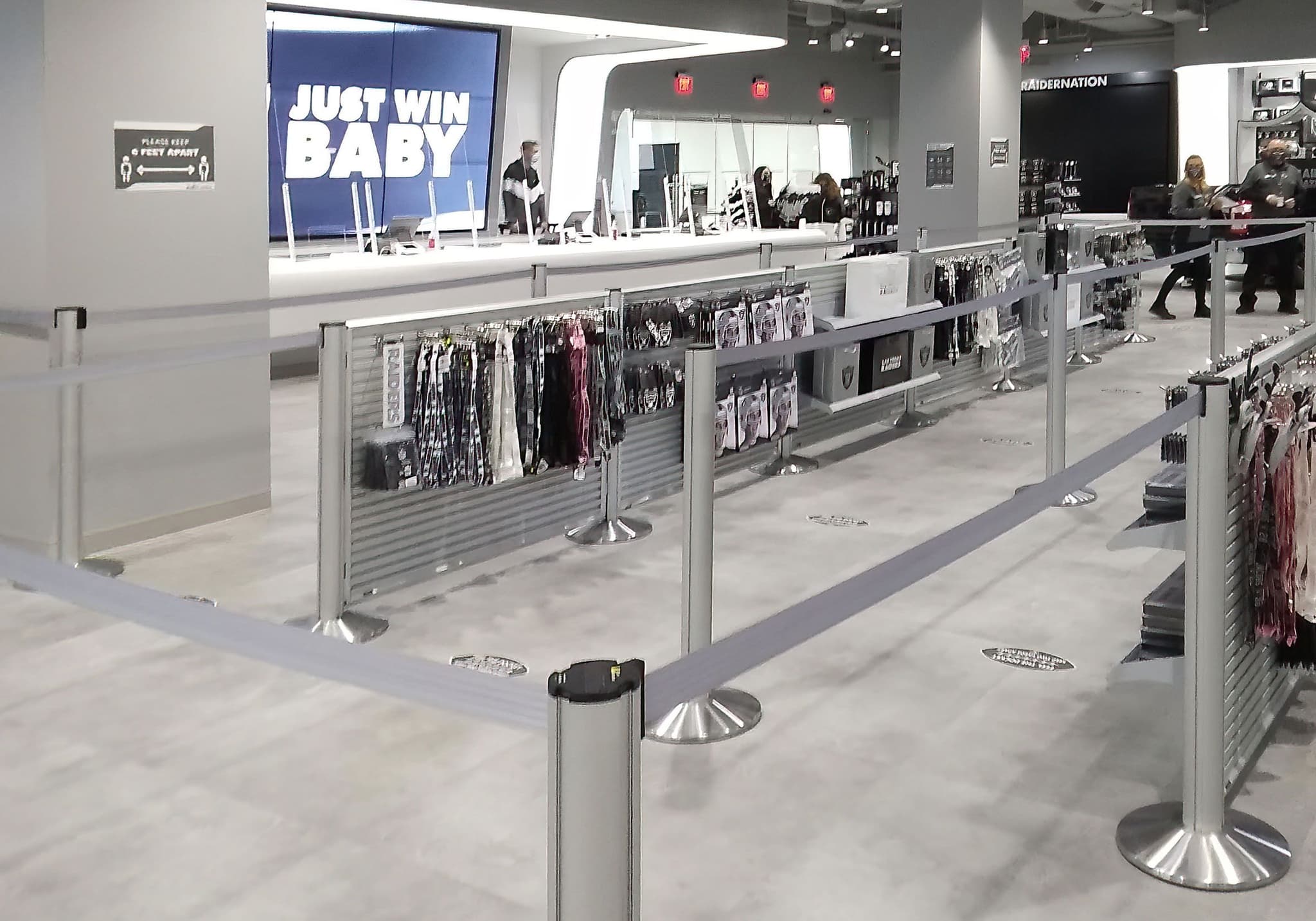 Beltrac retractable belt stanchions and slatwall displays merchandise the checkout queue in the Raiders team store in Las Vegas.