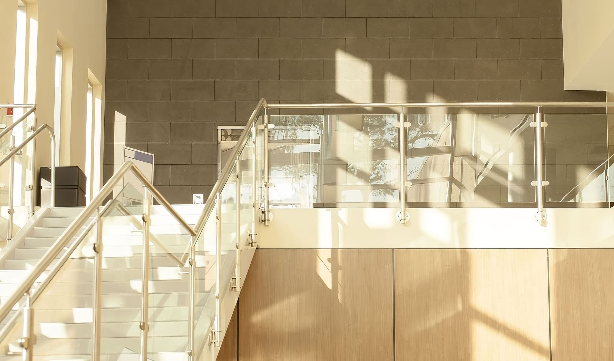 An architectural glass railing system serves as the guardrail and stair railing inside a commercial building.