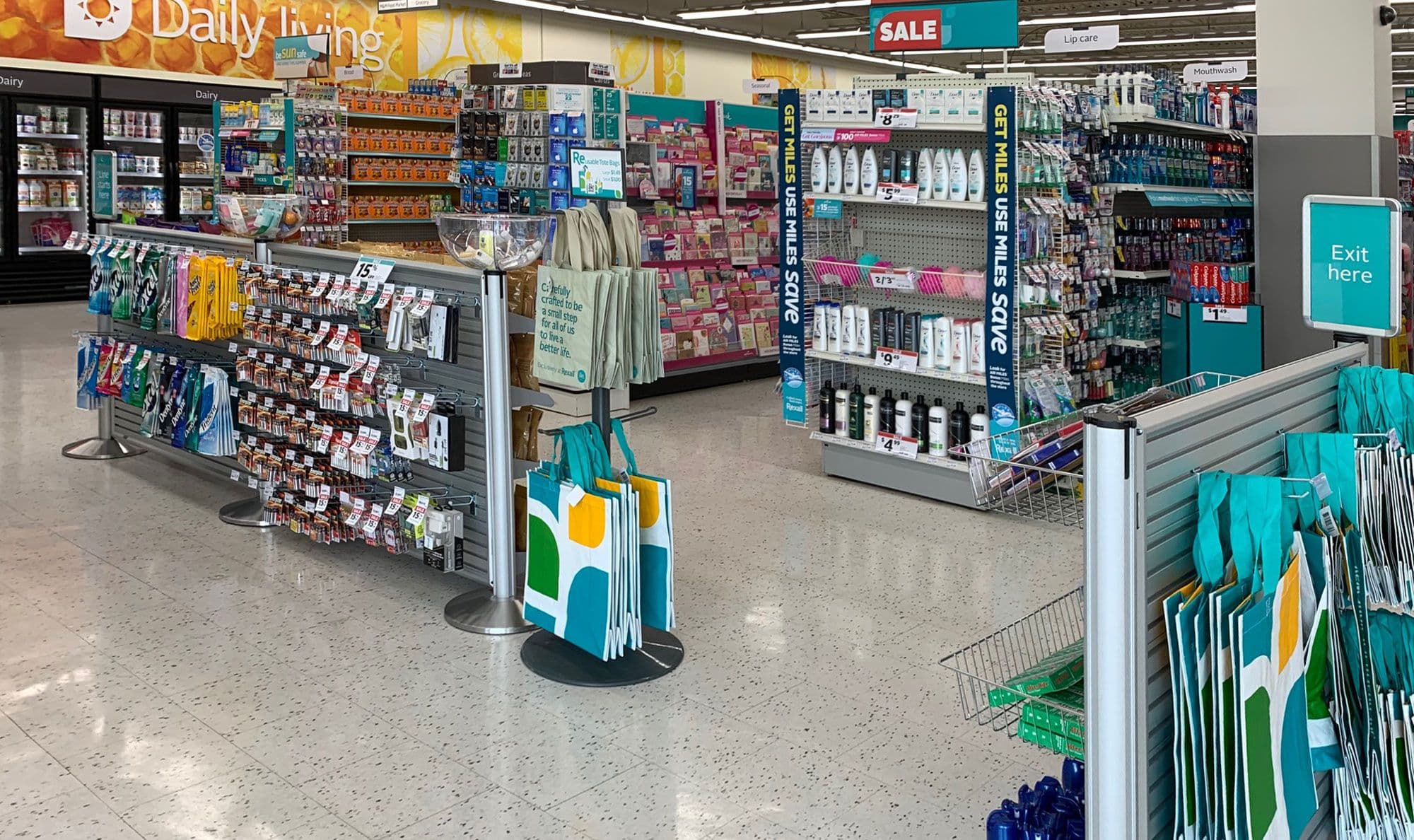 NeXtrac in-queue slatwall shelving displays products along the checkout line at a Rexall drugstore.