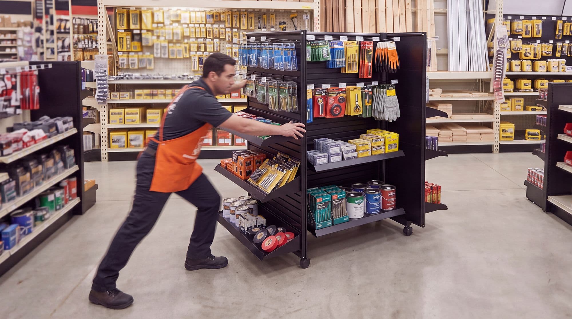 Employee rolling a mobile gondola through the store