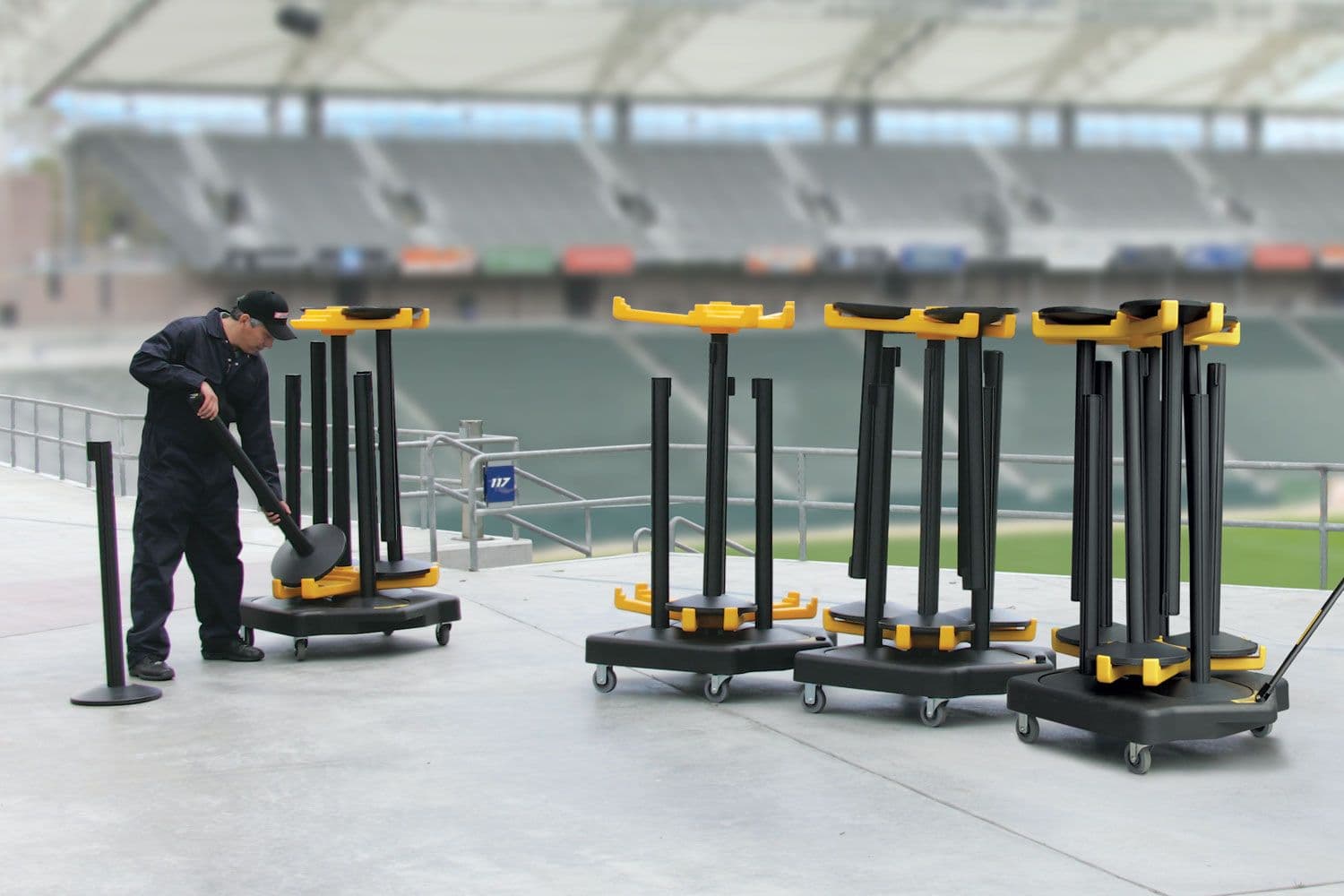 ShuttleTrac transport carts move and store Beltrac stanchions inside a stadium concourse.