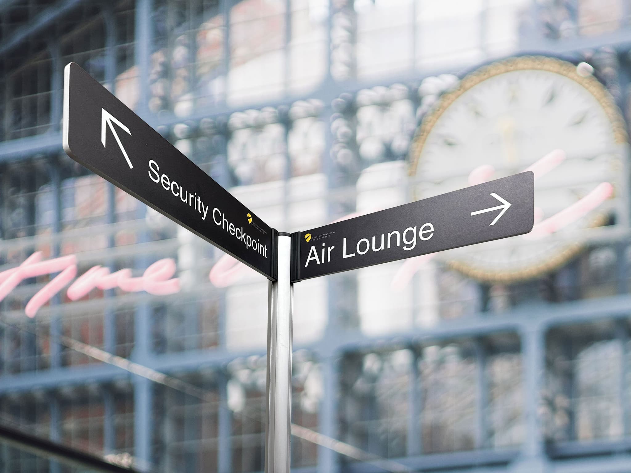 Tall partition posts with banner signs create street signs for wayfinding inside a terminal.