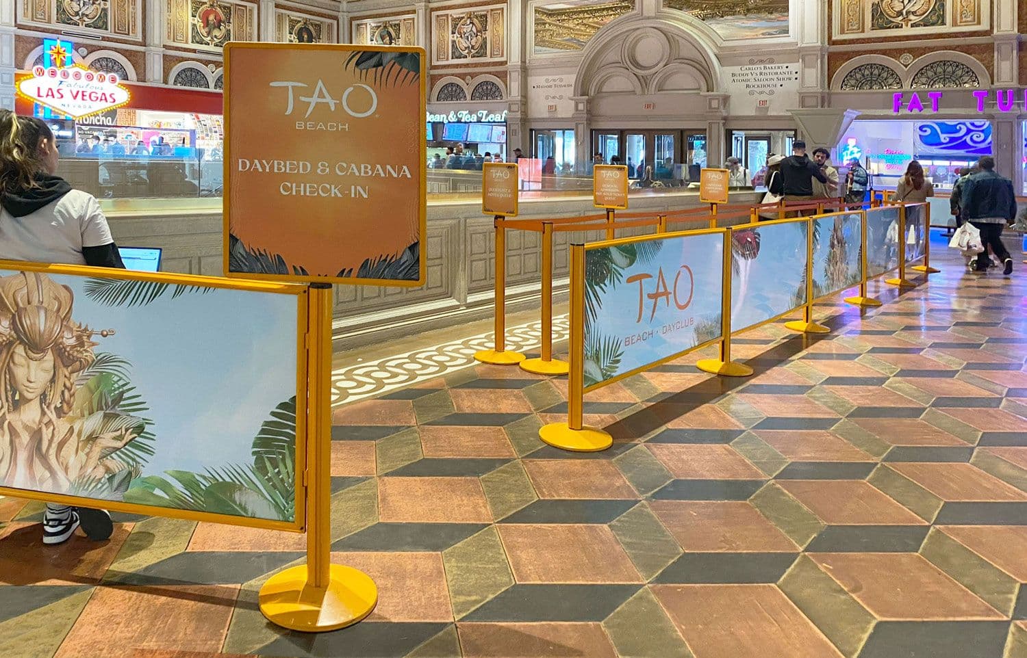 Post and Panel barriers with custom printed graphics form the cabana queue at TAO Beach Club in Las Vegas.