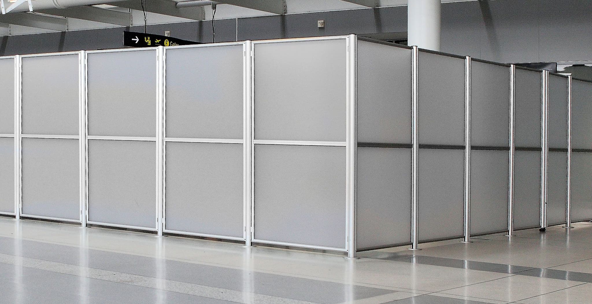 Tall partition posts and panels form a barrier wall around a secure area at Toronto Pearson International Airport.