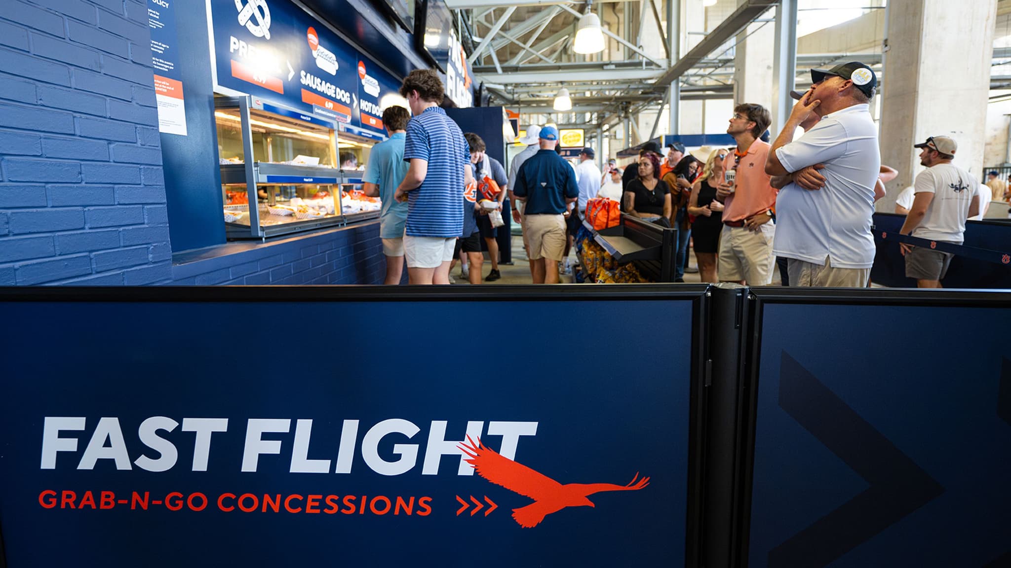 Rigid Rail barriers with printed Fast Flight graphics guide fans through the concession line at Auburn's Jordan-Hare Stadium.