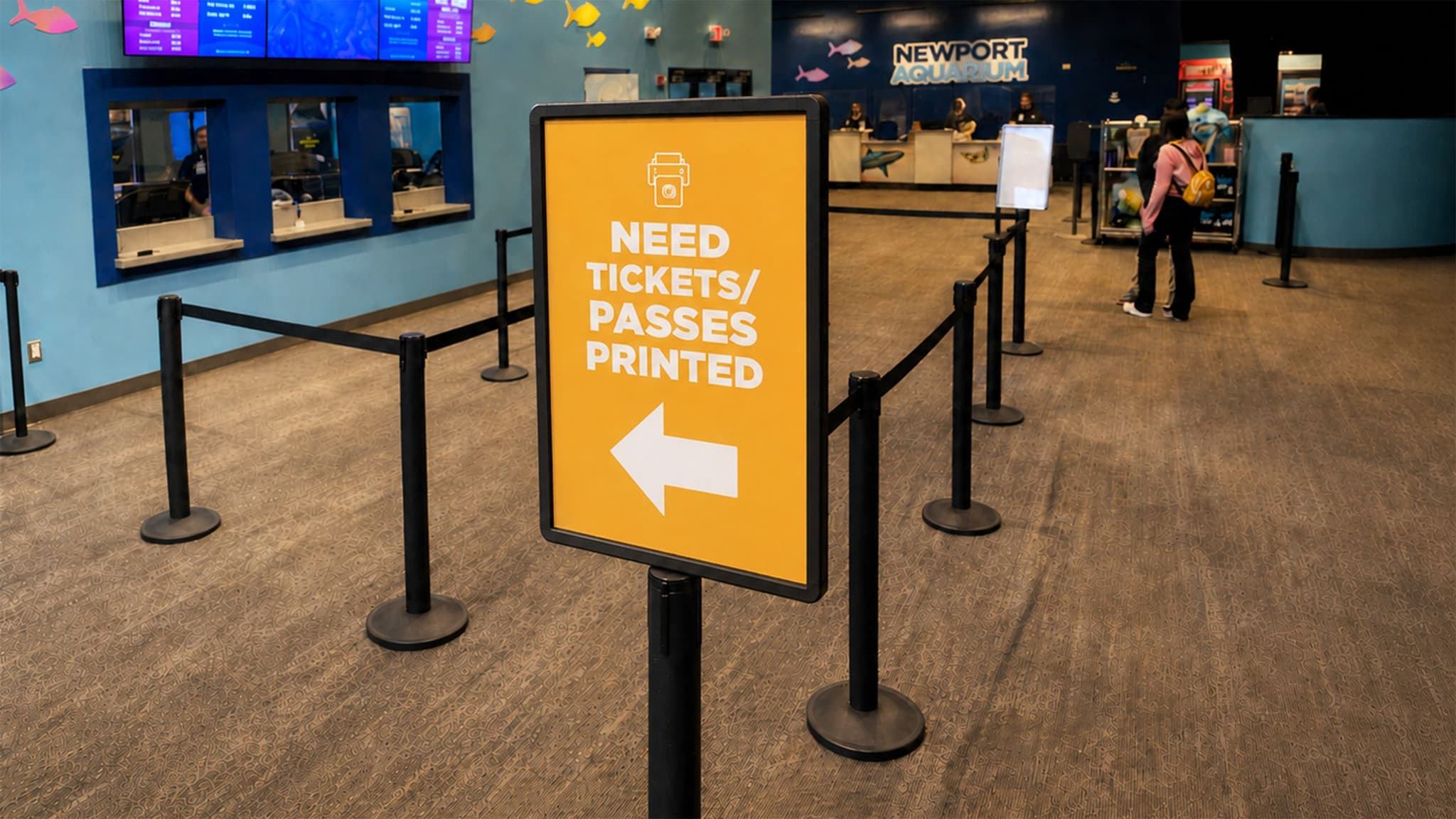 Beltrac retractable belt stanchions with a post-top sign guide visitors into the Newport Aquarium line.