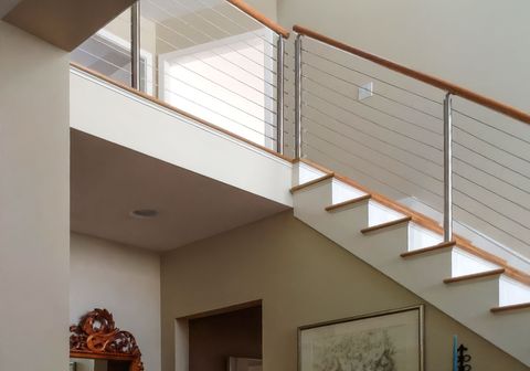 Cable railing with wood handrail on residential staircase